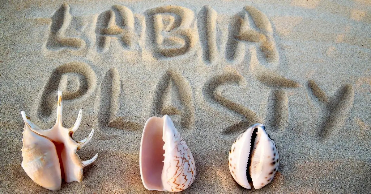 Labiaplasty written in sand with symbolic seashells, representing feminine wellness and cosmetic vaginal surgery concepts by Regenerative Aesthetics and Dermatology in Laguna Hills, CA